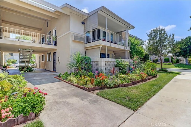 382 Avenida Castilla Unit B, Laguna Woods, CA 92637 - view of building exterior featuring concrete driveway, stairs, and a carport