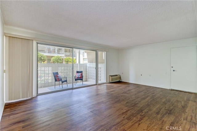 382 Avenida Castilla Unit B, Laguna Woods, CA 92637 - empty room featuring wood finished floors, a textured ceiling, and a wall mounted air conditioner
