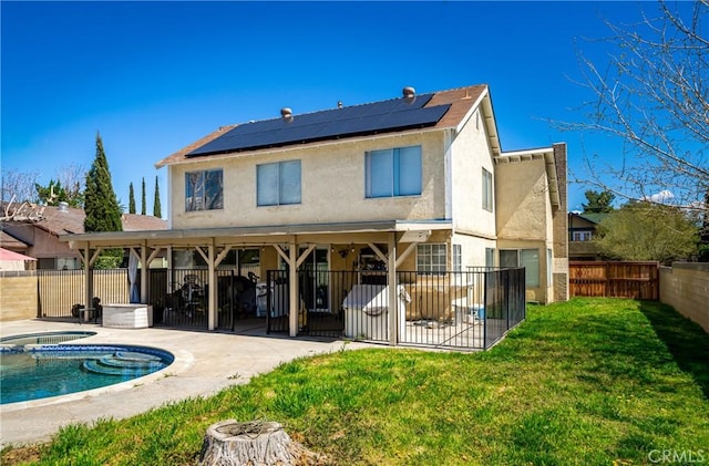 44419 Fenhold, Lancaster, CA 93535 - back of property with an in-ground hot tub, a patio area, solar panels, a fenced backyard, and stucco siding