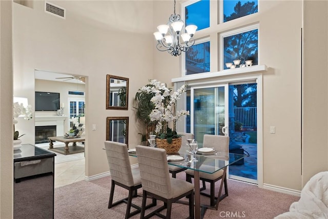 530 S Laureltree Dr, Anaheim Hills, CA 92808 - tiled dining space featuring a towering ceiling, carpet floors, a chandelier, a glass covered fireplace, and a ceiling fan