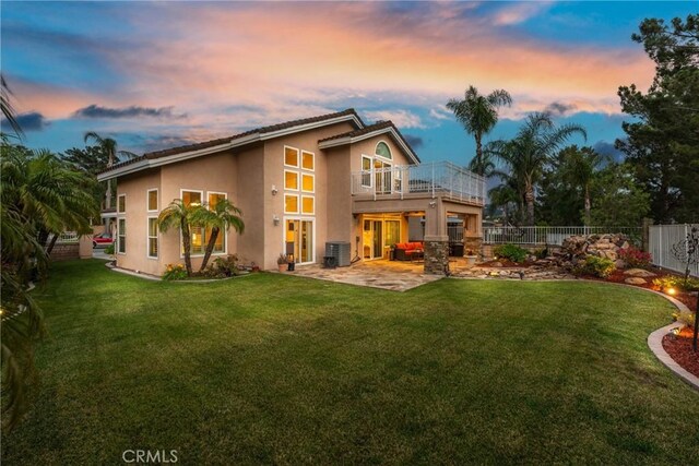 530 S Laureltree Dr, Anaheim Hills, CA 92808 - back of property at dusk with a balcony, stucco siding, a fenced backyard, a patio, and french doors