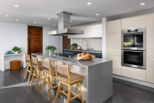 3879 Ocean Front Walk, San Diego, CA 92109 - kitchen with island range hood, appliances with stainless steel finishes, modern cabinets, a sink, and a breakfast bar