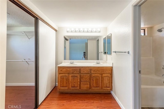 1573 E Brockton Ave, Redlands, CA 92374 - bathroom with bathing tub / shower combination, double vanity, wood finished floors, and a walk in closet
