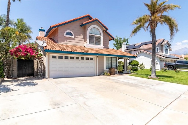 1573 E Brockton Ave, Redlands, CA 92374 - view of front facade featuring a tiled roof, driveway, a chimney, an attached garage, and a front yard