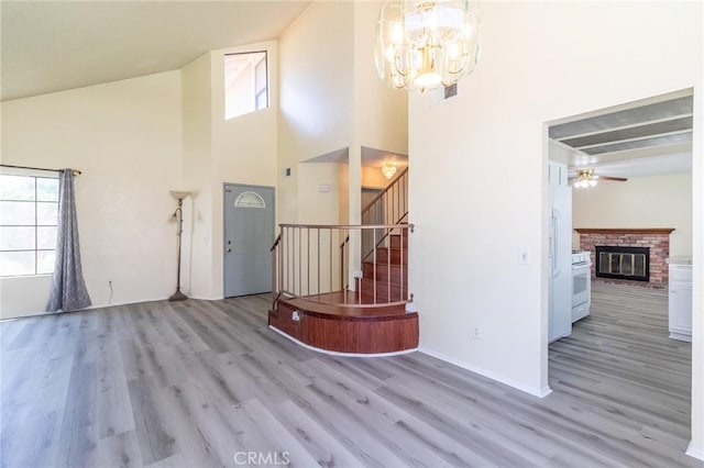 1573 E Brockton Ave, Redlands, CA 92374 - entrance foyer with plenty of natural light, wood finished floors, a chandelier, a fireplace, and a towering ceiling
