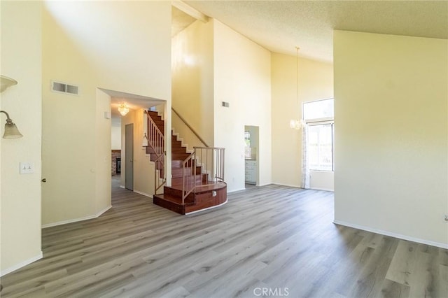 1573 E Brockton Ave, Redlands, CA 92374 - foyer featuring wood finished floors, high vaulted ceiling, stairway, baseboards, and a chandelier