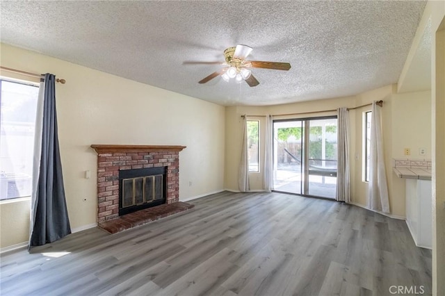 1573 E Brockton Ave, Redlands, CA 92374 - unfurnished living room with a textured ceiling, ceiling fan, wood finished floors, a fireplace, and baseboards
