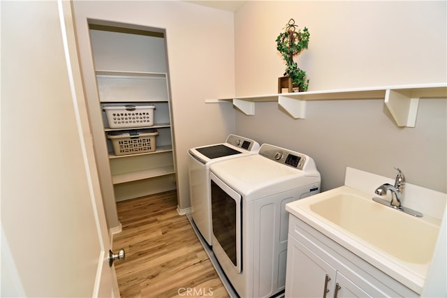35582 Laurel Tree Ct, Winchester, CA 92596 - laundry room featuring washing machine and dryer, light wood-type flooring, and cabinet space