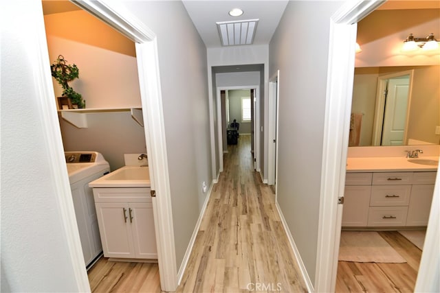 35582 Laurel Tree Ct, Winchester, CA 92596 - hall featuring washer / clothes dryer, light wood-style floors, and a sink
