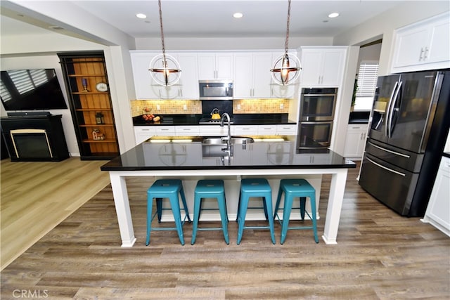 35582 Laurel Tree Ct, Winchester, CA 92596 - kitchen featuring appliances with stainless steel finishes, a sink, dark countertops, decorative backsplash, and white cabinetry