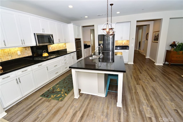 35582 Laurel Tree Ct, Winchester, CA 92596 - kitchen with stainless steel appliances, dark wood-type flooring, dark countertops, and recessed lighting