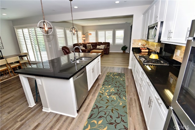 35582 Laurel Tree Ct, Winchester, CA 92596 - kitchen featuring stainless steel appliances, wood finished floors, a kitchen breakfast bar, recessed lighting, and open floor plan