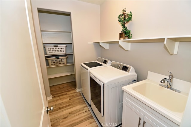 35582 Laurel Tree Ct, Winchester, CA 92596 - washroom featuring independent washer and dryer, light wood-style flooring, and cabinet space