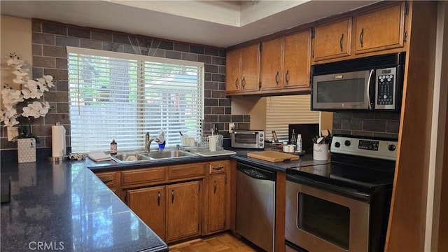 6286 Columbine Rd, Magalia, CA 95954 - kitchen featuring stainless steel appliances, a sink, brown cabinetry, and tasteful backsplash