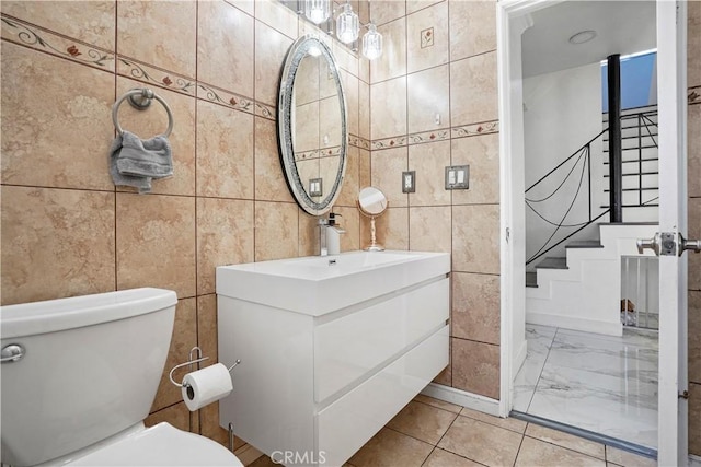 9021 Oneida Ave, Sun Valley, CA 91352 - half bath featuring tile walls, vanity, toilet, and marble look tile flooring