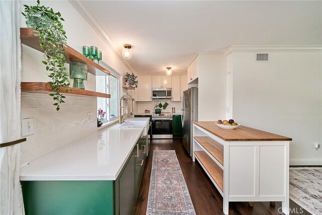 15544 Andorra Way, San Diego, CA 92129 - kitchen with open shelves, stainless steel appliances, dark wood finished floors, white cabinetry, and ornamental molding