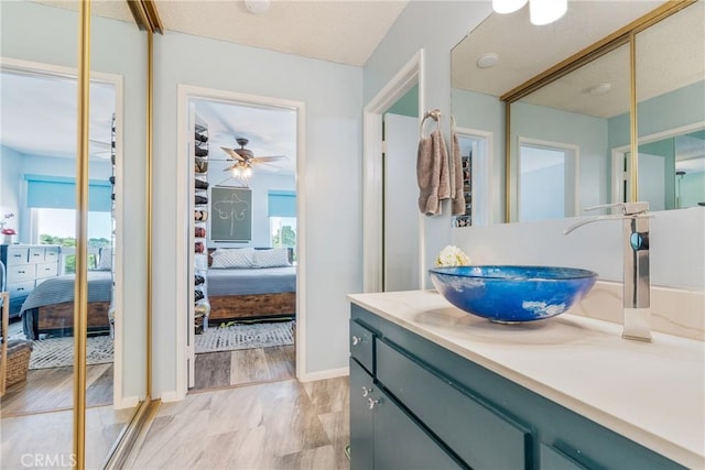 5585 E Pacific Coast Unit 361, Long Beach, CA 90804 - ensuite bathroom with vanity, plenty of natural light, a ceiling fan, and wood finished floors