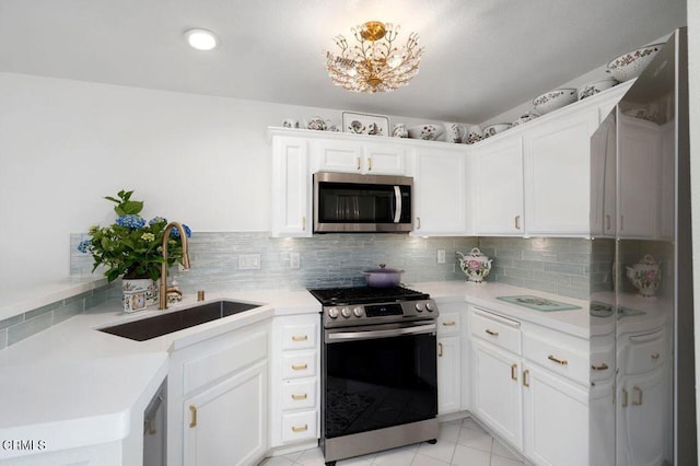 2911 Butter Creek Dr, Pasadena, CA 91107 - kitchen featuring appliances with stainless steel finishes, a sink, light countertops, backsplash, and white cabinets