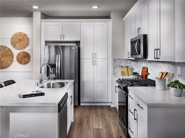 2732 Erebus Ct, Pomona, CA 91767 - kitchen featuring appliances with stainless steel finishes, a sink, dark wood-type flooring, a kitchen island with sink, and tasteful backsplash