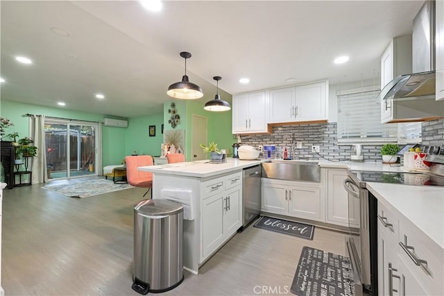 1257 E Grand Ave Unit A, Escondido, CA 92027 - kitchen with appliances with stainless steel finishes, wall chimney exhaust hood, a wall unit AC, a sink, and light wood-style floors