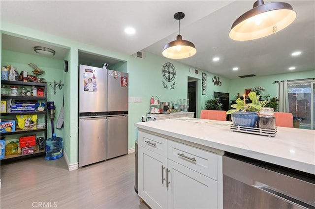 1257 E Grand Ave Unit A, Escondido, CA 92027 - kitchen featuring freestanding refrigerator, white cabinetry, light wood-style flooring, light countertops, and hanging light fixtures