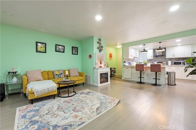 1257 E Grand Ave Unit A, Escondido, CA 92027 - living room featuring light wood-type flooring, recessed lighting, and a glass covered fireplace
