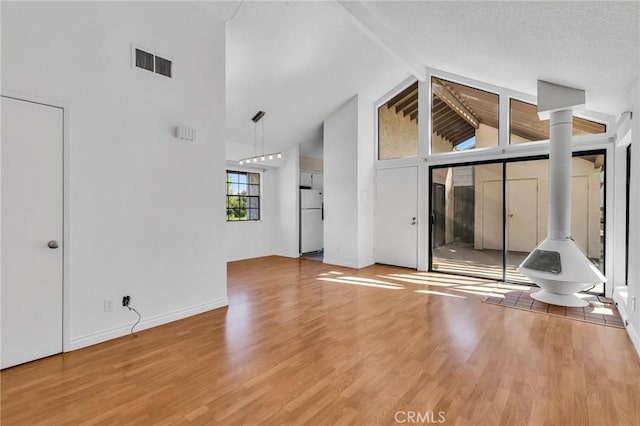 26701 Quail Unit 61, Laguna Hills, CA 92656 - unfurnished living room with high vaulted ceiling, wood finished floors, baseboards, and beam ceiling