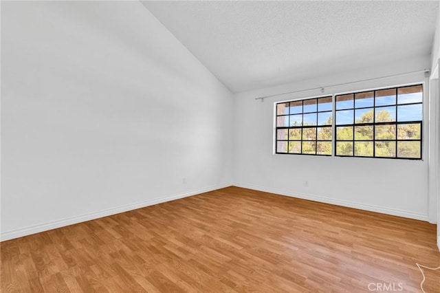 26701 Quail Unit 61, Laguna Hills, CA 92656 - unfurnished room featuring lofted ceiling, light wood finished floors, baseboards, and a textured ceiling
