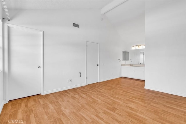 26701 Quail Unit 61, Laguna Hills, CA 92656 - unfurnished living room featuring beamed ceiling, light wood-style flooring, high vaulted ceiling, and baseboards