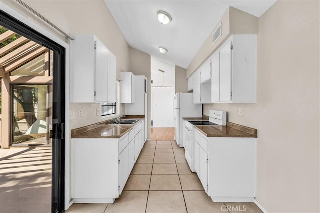 26701 Quail Unit 61, Laguna Hills, CA 92656 - kitchen with white appliances, dark countertops, a sink, and white cabinetry