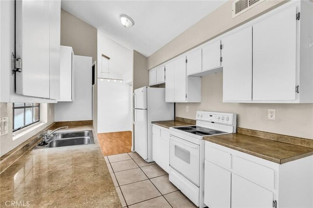26701 Quail Unit 61, Laguna Hills, CA 92656 - kitchen featuring white appliances, a sink, white cabinetry, light tile patterned flooring, and vaulted ceiling