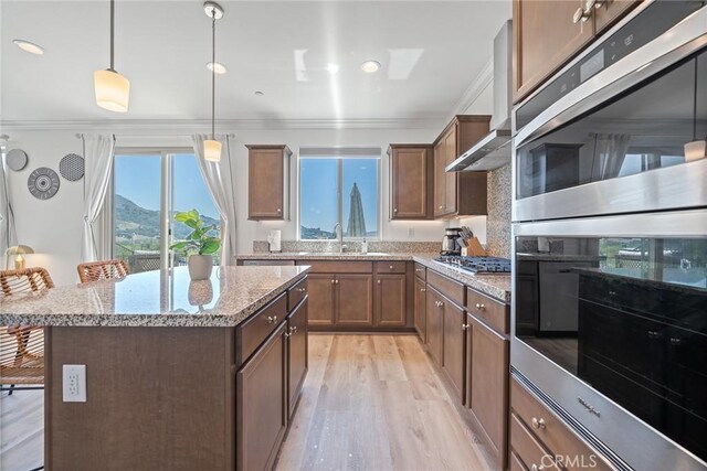 843 Longhorn Way, Rancho Mission Viejo, CA 92694 - kitchen with a sink, crown molding, appliances with stainless steel finishes, a center island, and light wood-style flooring