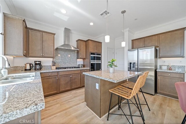 843 Longhorn Way, Rancho Mission Viejo, CA 92694 - kitchen featuring appliances with stainless steel finishes, wall chimney exhaust hood, a sink, a center island, and a breakfast bar area