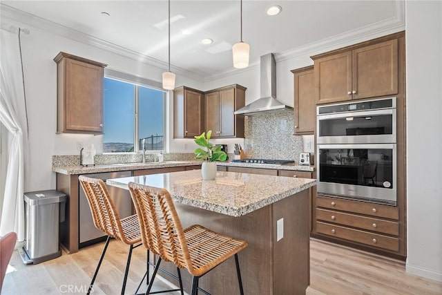 843 Longhorn Way, Rancho Mission Viejo, CA 92694 - kitchen with wall chimney range hood, stainless steel appliances, a sink, a kitchen island, and light wood-type flooring