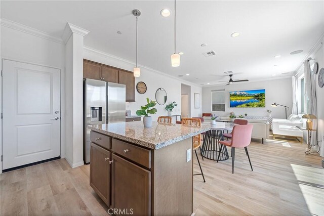 843 Longhorn Way, Rancho Mission Viejo, CA 92694 - kitchen with stainless steel fridge, a kitchen bar, open floor plan, ornamental molding, and a kitchen island