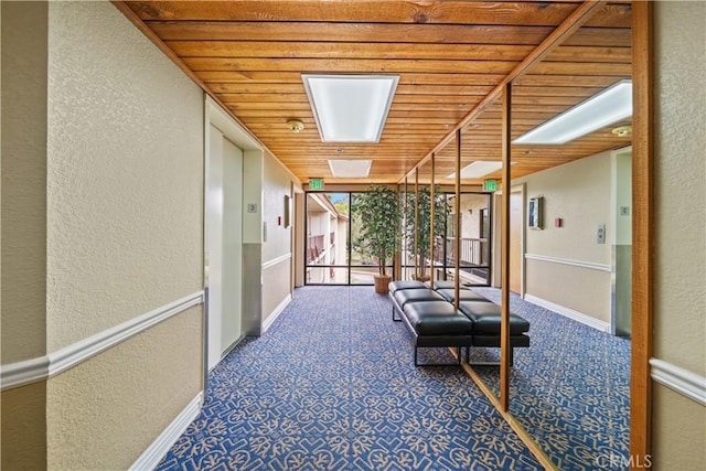 13601 Del Monte Dr Unit 75, Seal Beach, CA 90740 - corridor with a textured wall, wooden ceiling, baseboards, carpet flooring, and floor to ceiling windows