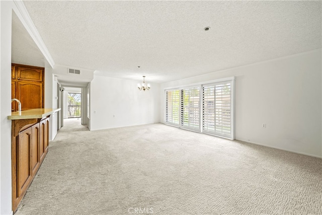 13601 Del Monte Dr Unit 75, Seal Beach, CA 90740 - unfurnished living room featuring a textured ceiling, light colored carpet, a chandelier, healthy amount of natural light, and ornamental molding