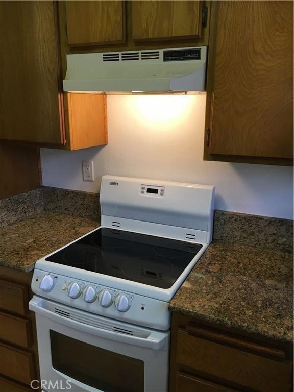 23375 La Crescenta Unit C274, Mission Viejo, CA 92691 - kitchen with electric stove, under cabinet range hood, and brown cabinetry