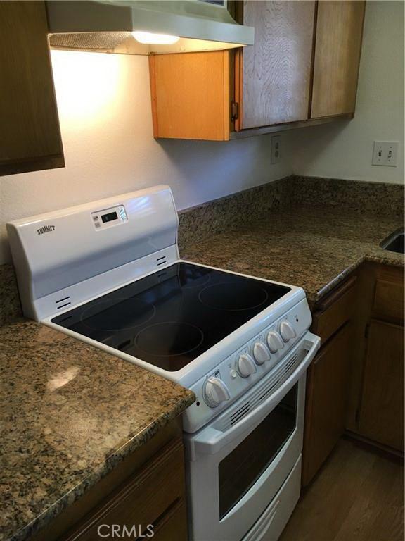 23375 La Crescenta Unit C274, Mission Viejo, CA 92691 - kitchen with white electric range oven, wall chimney exhaust hood, and dark countertops