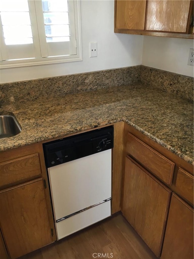 23375 La Crescenta Unit C274, Mission Viejo, CA 92691 - kitchen featuring white dishwasher, brown cabinetry, dark wood-type flooring, and dark stone counters