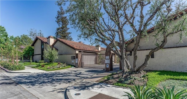 1364 Park Plaza Dr, Long Beach, CA 90804 - view of front of home featuring a gate, a chimney, stucco siding, and driveway