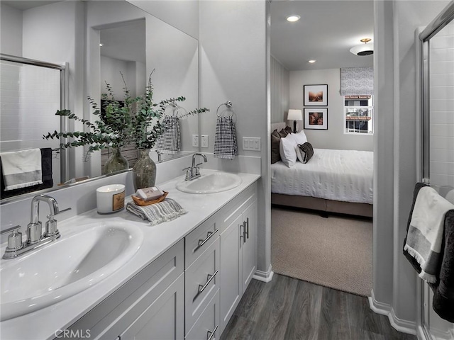 209 Aurora Ln, Pomona, CA 91767 - ensuite bathroom with wood finished floors, double vanity, a shower with shower door, and recessed lighting