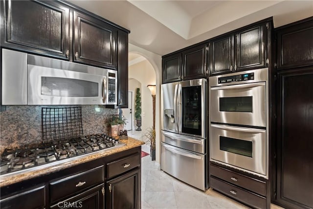 16 Via Barcaza, Coto De Caza, CA 92679 - kitchen featuring appliances with stainless steel finishes, arched walkways, and backsplash