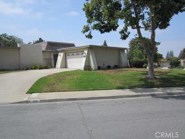428 Champlain Dr, Claremont, CA 91711 - view of front facade featuring concrete driveway, a front lawn, a garage, stucco siding, and mansard roof