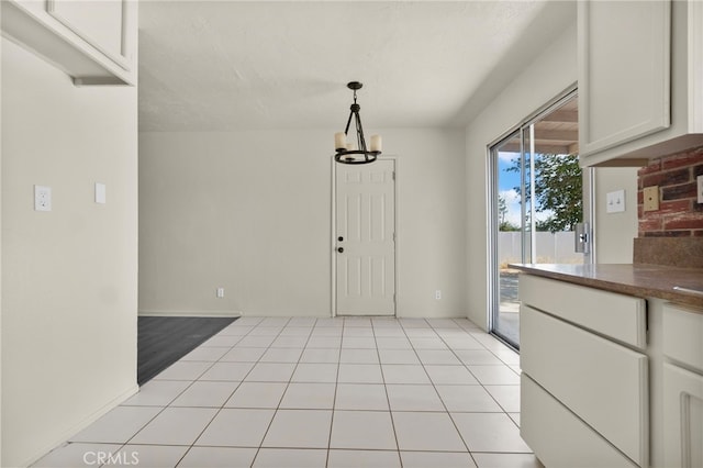 10793 Jamul Rd, Apple Valley, CA 92308 - unfurnished dining area with a chandelier and light tile patterned floors