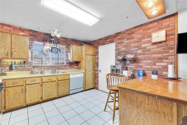 6765 Jadeite Ave, Rancho Cucamonga, CA 91701 - kitchen with white dishwasher, brick wall, a sink, light countertops, and light tile patterned floors