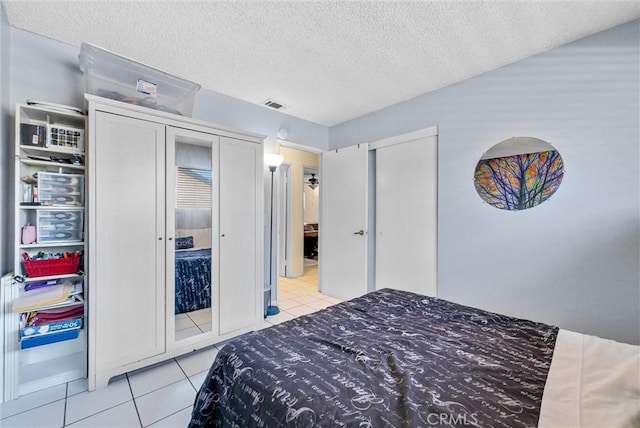 6765 Jadeite Ave, Rancho Cucamonga, CA 91701 - bedroom featuring light tile patterned floors, multiple closets, and a textured ceiling