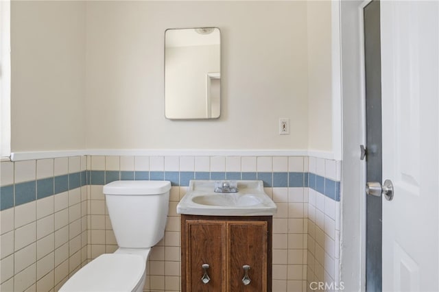 124 S Glengrove Ave, San Dimas, CA 91773 - bathroom with toilet, vanity, wainscoting, and tile walls