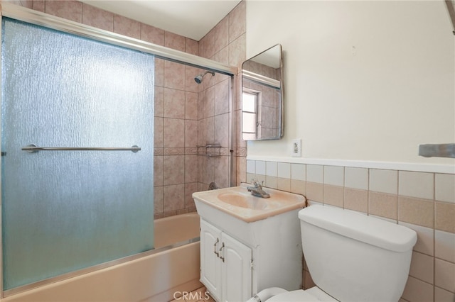 124 S Glengrove Ave, San Dimas, CA 91773 - bathroom with vanity, toilet, bath / shower combo with glass door, tile walls, and a wainscoted wall