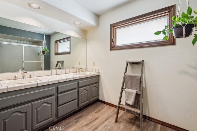 6978 Withers Rd, Riverside, CA 92506 - full bathroom with double vanity, wood finished floors, a shower with shower door, and plenty of natural light